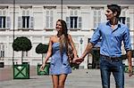 Young couple walking outdoors, hand in hand, Turin, Piedmont, Italy