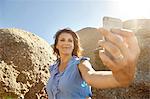Mature woman taking selfie with smartphone