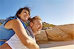 Man carrying woman on beach, Cape Town, South Africa