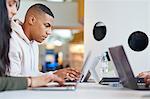 University students using laptops and digital tablet, working together