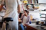 Woman in office drinking coffee chatting to colleague