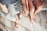 Couple sitting on edge of bed, holding hands, overhead view