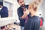 Male make up artist applying blusher to model for photo shoot