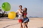 Young couple on beach playing with balloons, Koh Samui, Thailand