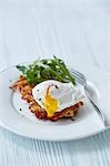 A potato fritter with a poached egg and rocket