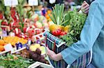 A woman at a market with a full shopping bag