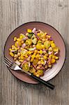 A yellow vegetable salad with tomatoes, sweetcorn, peppers and chickpeas