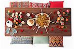 Tabbouleh in a large terracotta bowl with spoons and unleavened bread on a wooden table