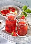 Strawberry jam in jars and on bread