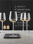 Glasses of white wine on a grey counter in a wine bar