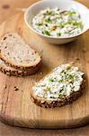 A slice of bread with goats' cheese, spring onion, dandelion greens, thyme and walnuts