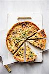 A sliced cheese & onion quiche with rosemary