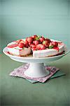 Strawberry cheesecake with strawberry sauce on a cake stand