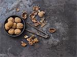 Whole walnuts, nut shells, a nutcracker and walnut seeds