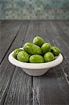 Olives (from Arbosana, Chile) in a bowl on a wooden surface