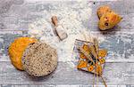 Assorted fresh breads on an old wooden table with flour and a napkin