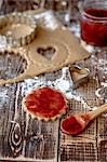 Jam being spread onto unbaked vegan shortbread biscuits