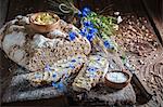 Homemade wholemeal bread with butter and salt on an old wooden board