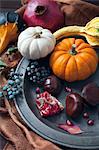 An autumnal arrangement of pumpkins, chestnuts, pomegranates and berries