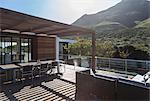 Sunny modern luxury home showcase exterior balcony patio with mountain view