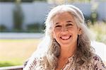 Portrait smiling mature woman in sunny garden