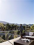 Pensive businessman on sunny balcony patio, looking at mountain view