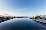 Tranquil luxury infinity pool with mountain view below blue sky