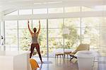 Woman practicing yoga mountain pose in luxury hotel bedroom