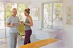 Couple in pajamas using digital tablet in luxury hotel bedroom