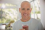 Portrait smiling, confident mature man drinking healthy fruit smoothie