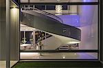 Illuminated spiral staircase in modern luxury home showcase interior