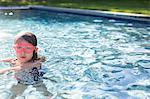 Portrait of girl in pink swimming goggles in outdoor swimming pool
