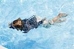 Overhead view of boy swimming in outdoor swimming pool