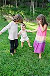 Female toddler with boy and girl in garden