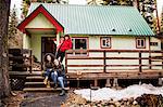 Portrait of three friends in front of cabin