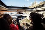 Woman driving car, friend in passenger seat looking at map