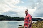 Mid adult man looking out at coast of Maine, USA