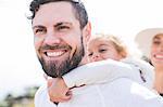 Girl having piggy back from father at coast