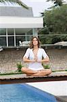 Woman doing yoga at home by the pool