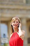 Pretty blonde woman doing sightseeing in Berlin and talking on the phone