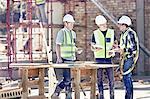 Construction workers and foreman talking at sunny construction site