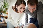 Playful parents looking down at baby daughter