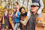 Playful multi-generation family walking in autumn park