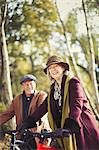 Portrait smiling senior couple bike riding in autumn park