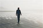 Middle aged man walking on a beach at Seabrook, Washington, USA.