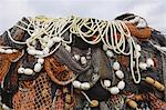Close up of a pile of tangled up commercial fishing nets with floats attached.