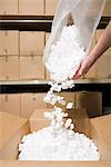 Person putting packing peanuts in box