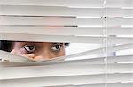 Woman looking through blinds