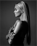 hairstyle, haircare and fashion concept - natural blond woman profile portrait with beautiful hair on grey background in monochrome