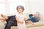Baby girl toddling in living room with parents watching